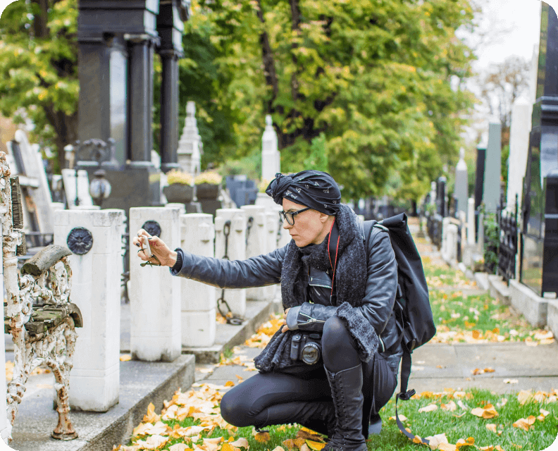 Person photographing in a cemetery during autumn.