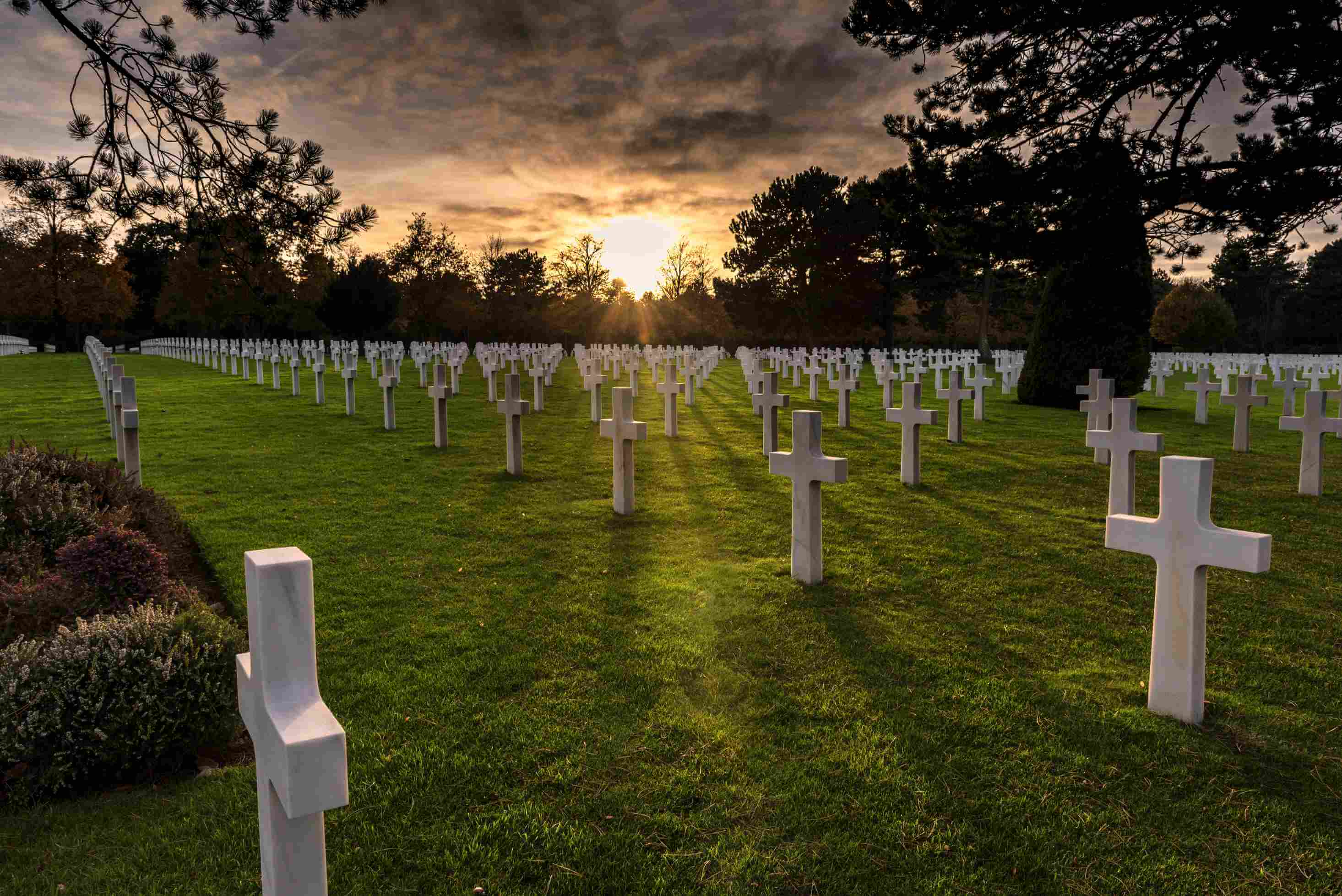 Cemetery at sunset with white crosses.