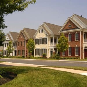 Row of modern suburban houses with well-kept lawns.