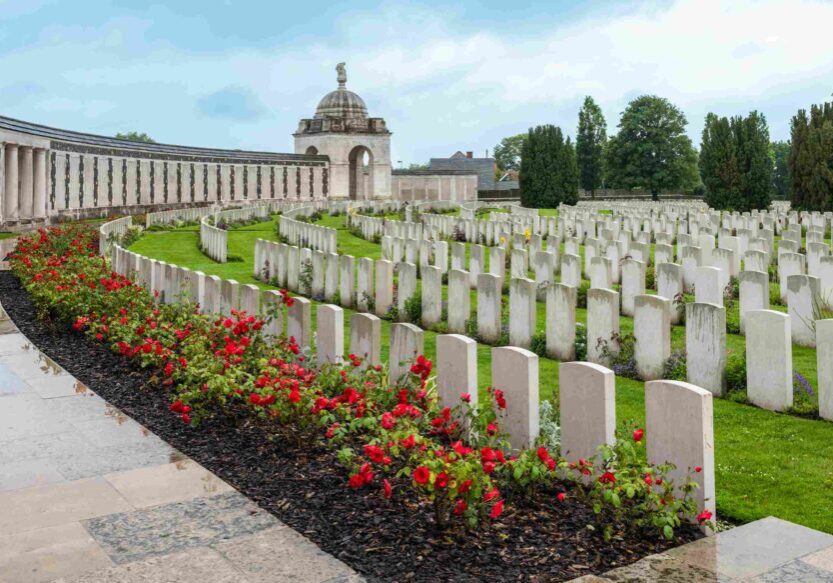 War cemetery with headstones and red flowers.